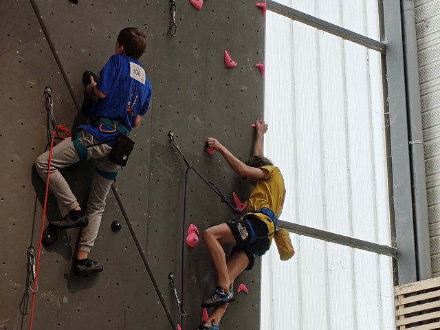 Deux grimpeurs dont un en maillot jaune Clamart Escalade sur le mur Entre-Prises du championnat de difficulté 92 à Toussus, mars 2026